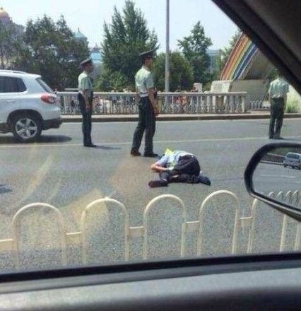 交警被撞出大概10米左右，趴在地上一動(dòng)不動(dòng)。